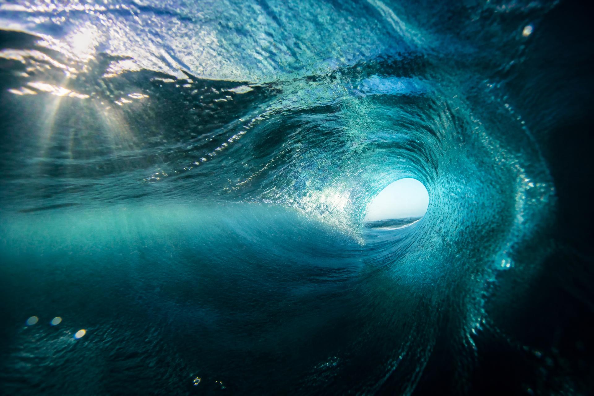 Sunlight piercing through the inside of a curling ocean wave